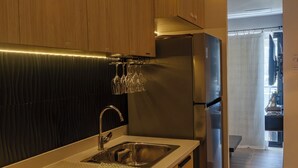 Una cocina moderna con armarios de madera, electrodomésticos de acero inoxidable y una vinoteca integrada.