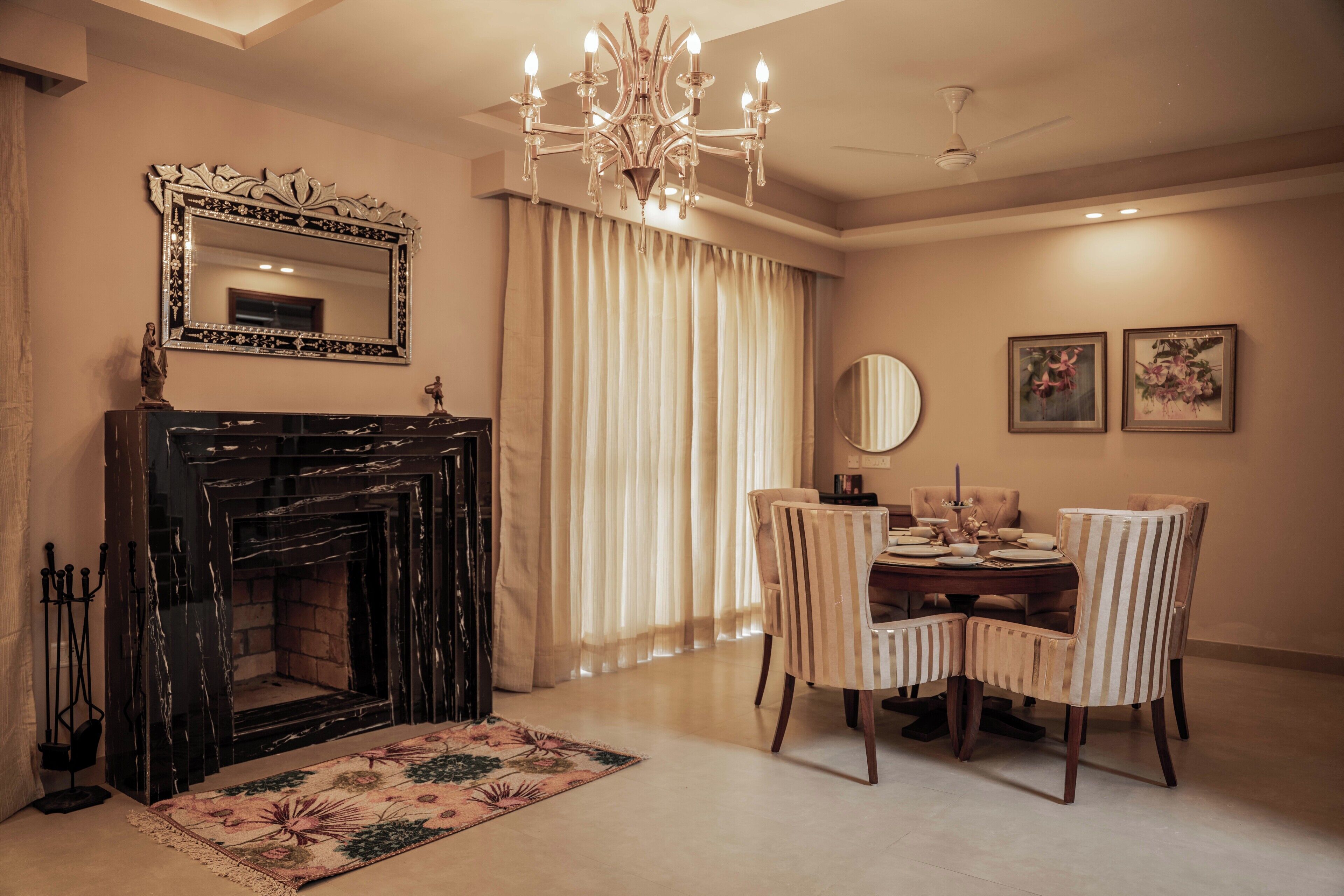A dining area with a chandelier, a fireplace, and a dining table with chairs.