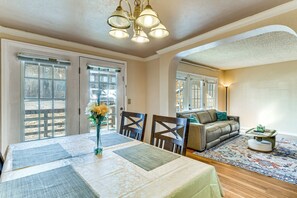 A dining area with a table set for two, a vase with flowers, and a view through the glass doors. - Extended Stay in Denver Area! Pet-Friendly Retreat (Aurora)