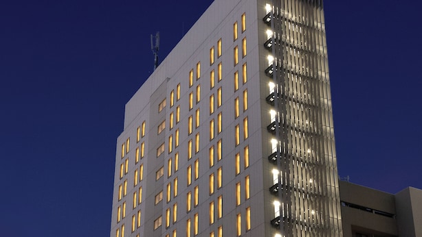 Korkea kerrostalo, jossa on useita kerroksia ja lukuisia ikkunoita, todennäköisesti hotelli tai toimistorakennus.