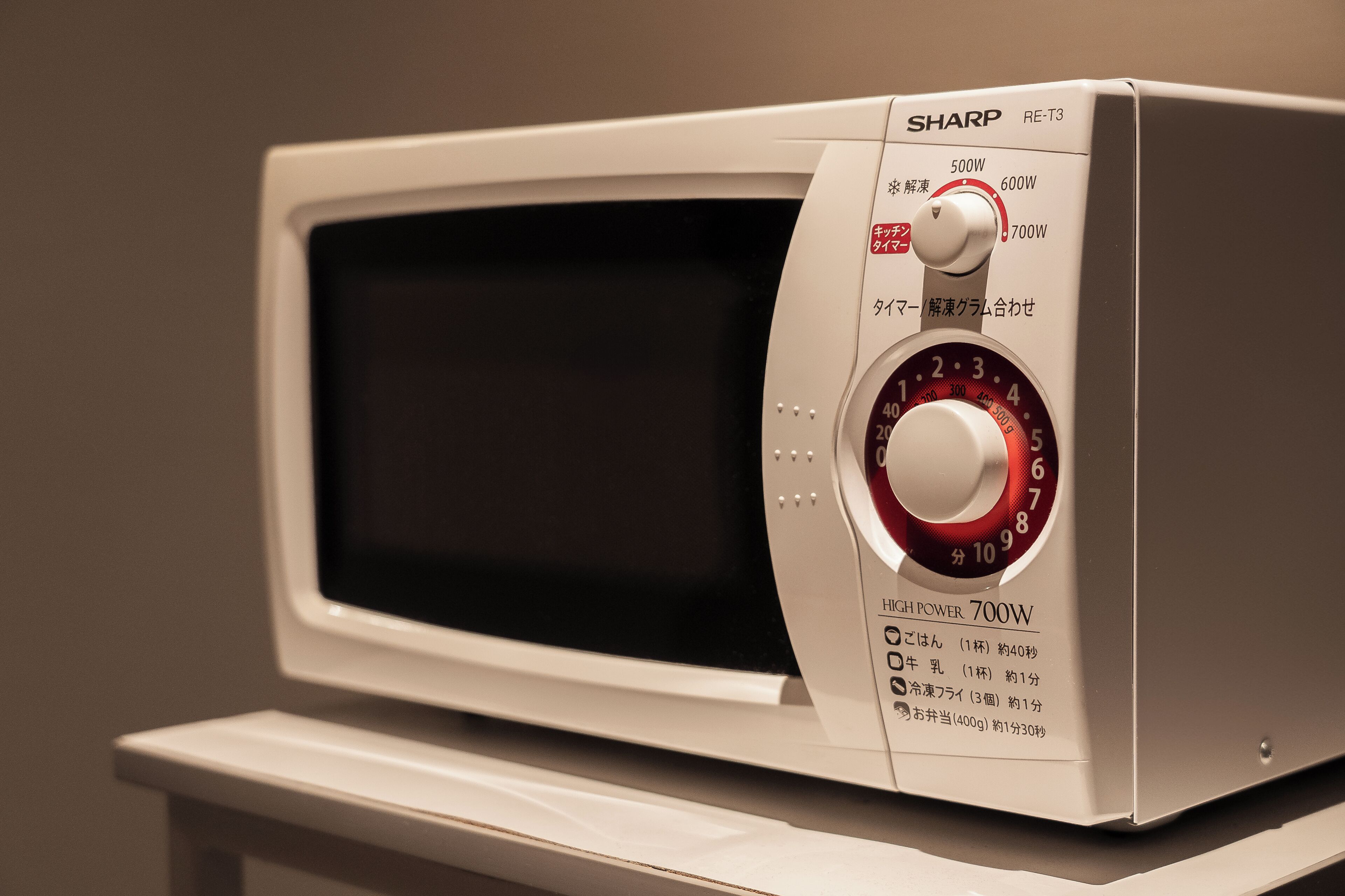 A microwave with a control panel, including a power dial and a digital display.
