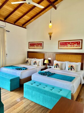 A hotel room with two beds, a wooden ceiling, a ceiling fan, a wall-mounted light fixture, and two wall-mounted artworks. - The Grand Hanthana (Kandy)