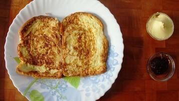A plate with two grilled cheese sandwiches and a small bowl of jam.