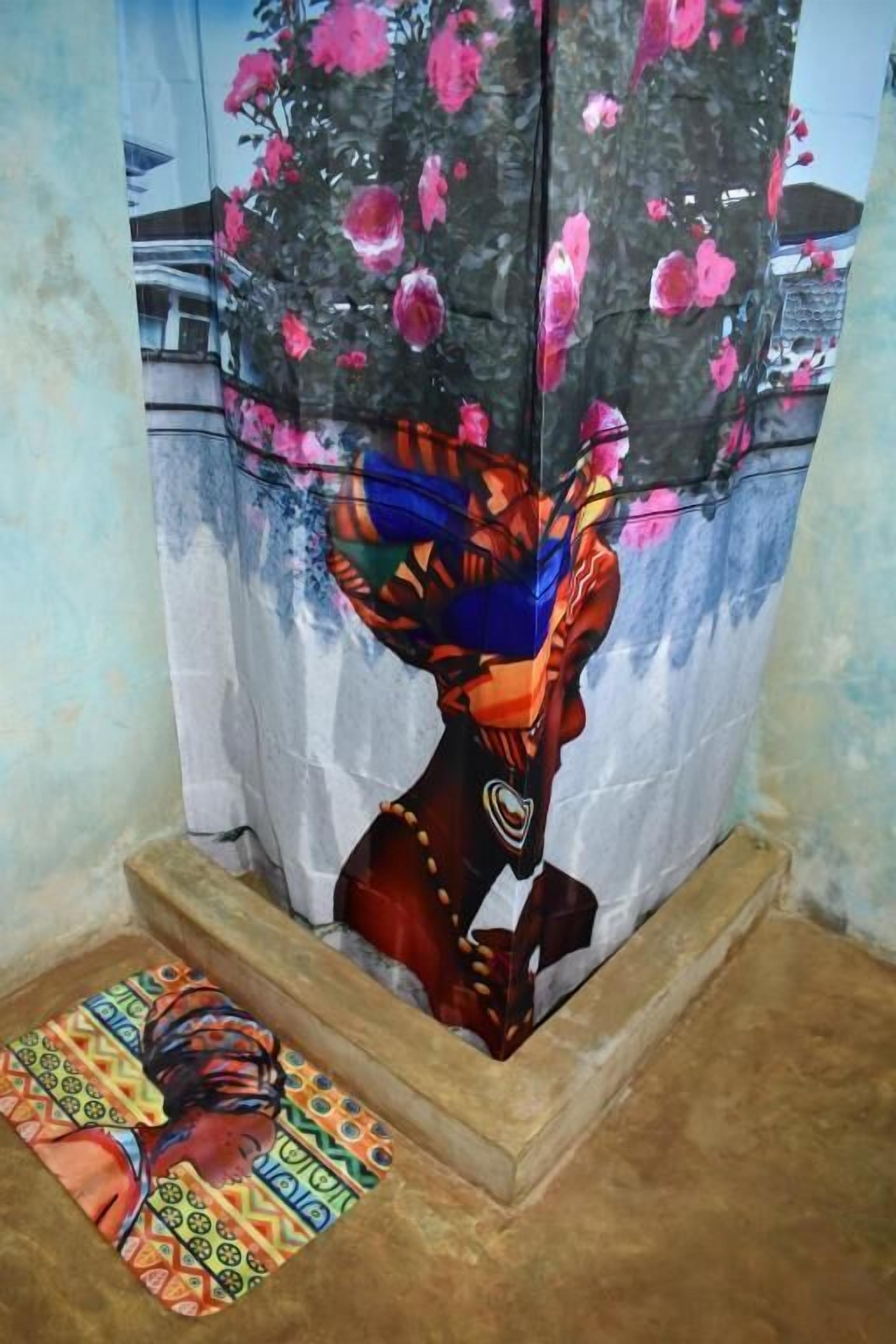 Una habitación con una obra de arte colorida en la pared, un tapete estampado en el suelo y una cortina con diseño floral.