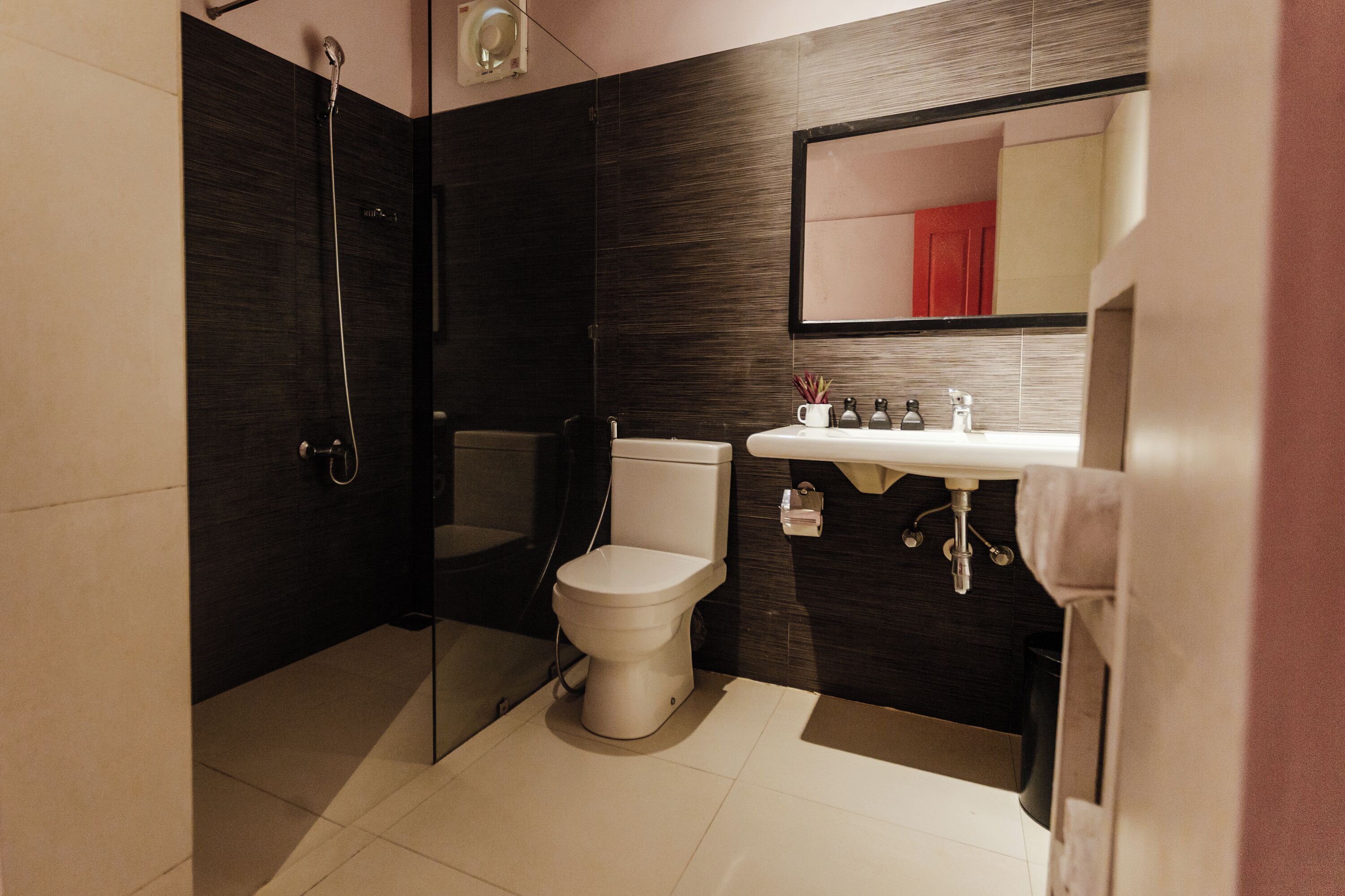 A modern bathroom with a toilet, sink, and shower.