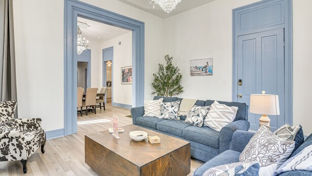 Un soggiorno con un divano blu, un tavolino in legno e una poltrona a fantasia.