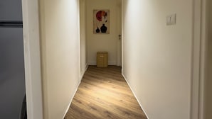 A narrow hallway with wooden flooring, white walls, and a ceiling light. - The Heart of Heliopolis 76 El Hegaz St (Cairo)