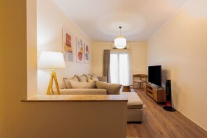Ein modernes Wohnzimmer mit einer Couch, einem Fernseher und einer Lampe.