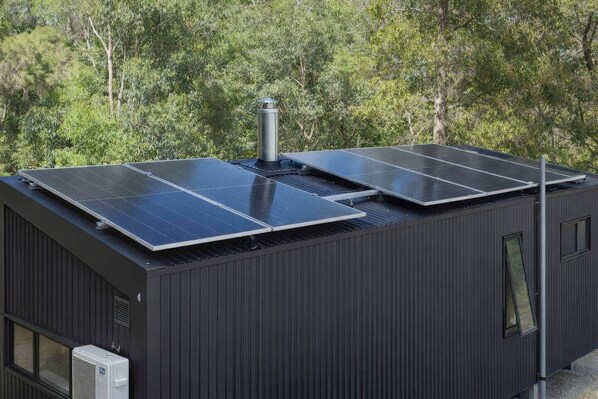 Een modern gebouw met zonnepanelen op het dak en een klein raam.