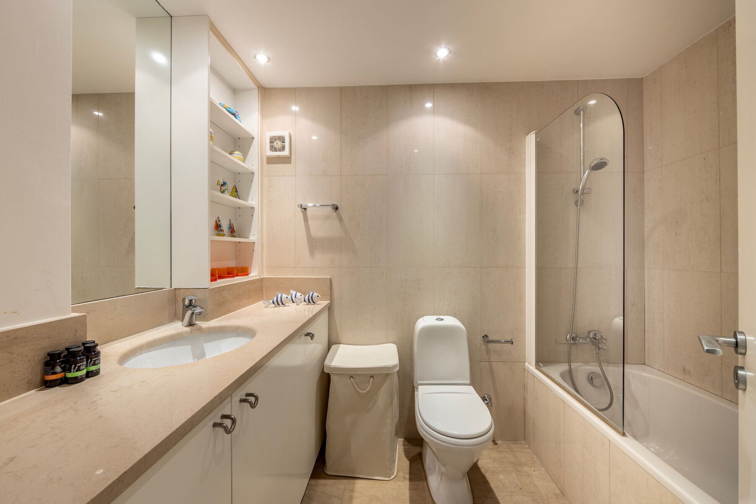 A modern bathroom with a sink, toilet, and bathtub.