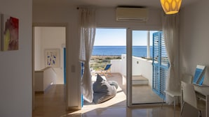Ein Zimmer mit Meerblick, einem Bett, einem Schreibtisch und einem Stuhl.