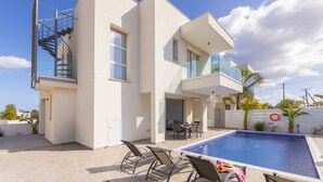 A modern two-story house with a swimming pool, outdoor seating, and a spiral staircase. - Protaras Sol e Mar Villa 2 (Paralimni)