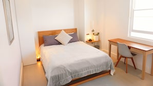 A bedroom with a bed, a desk, and a chair. - Sunny Side Up North Bondi (North Bondi)