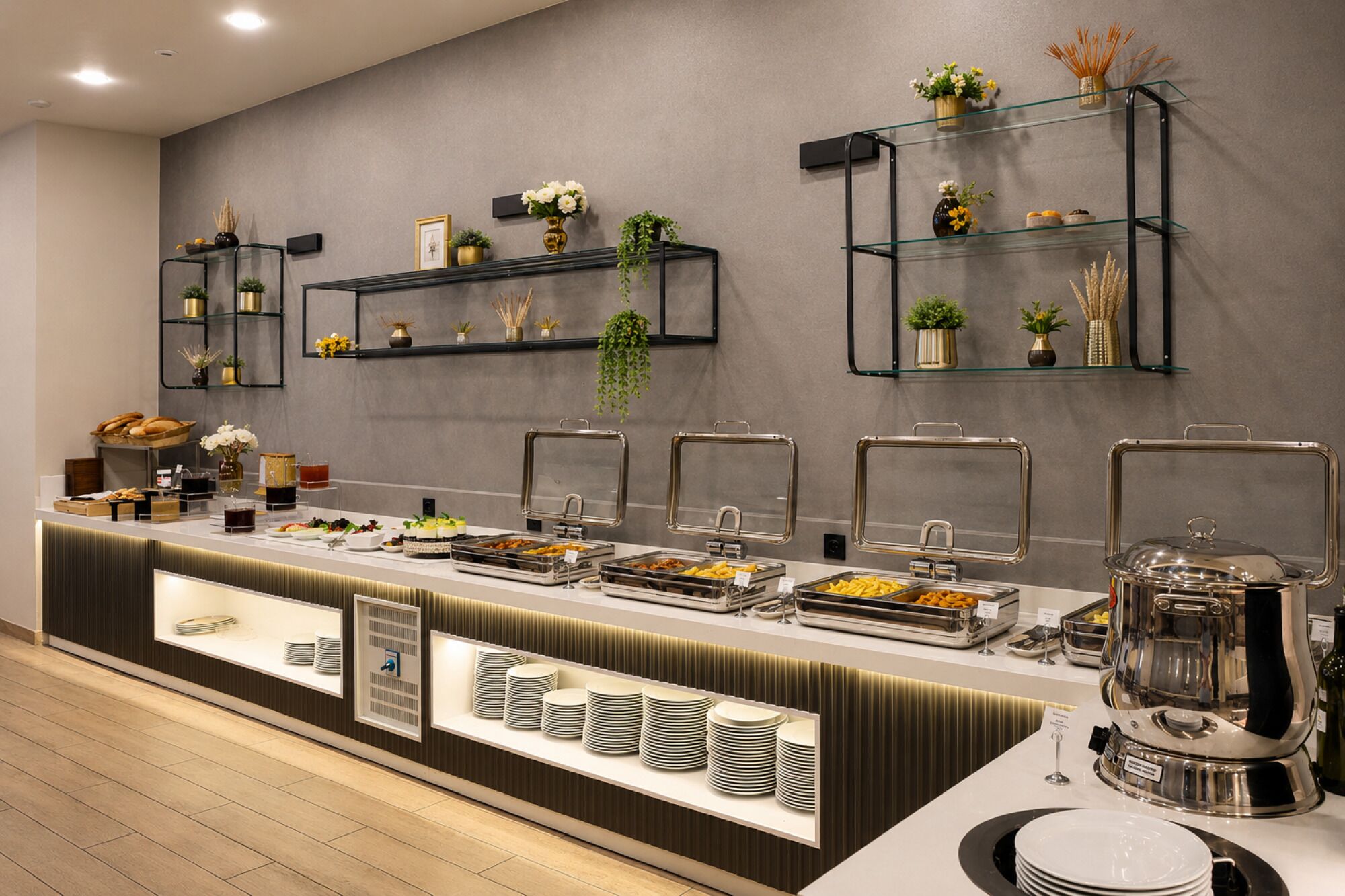 A buffet setup with multiple serving stations, glass shelves with decorative items, and a variety of food options.