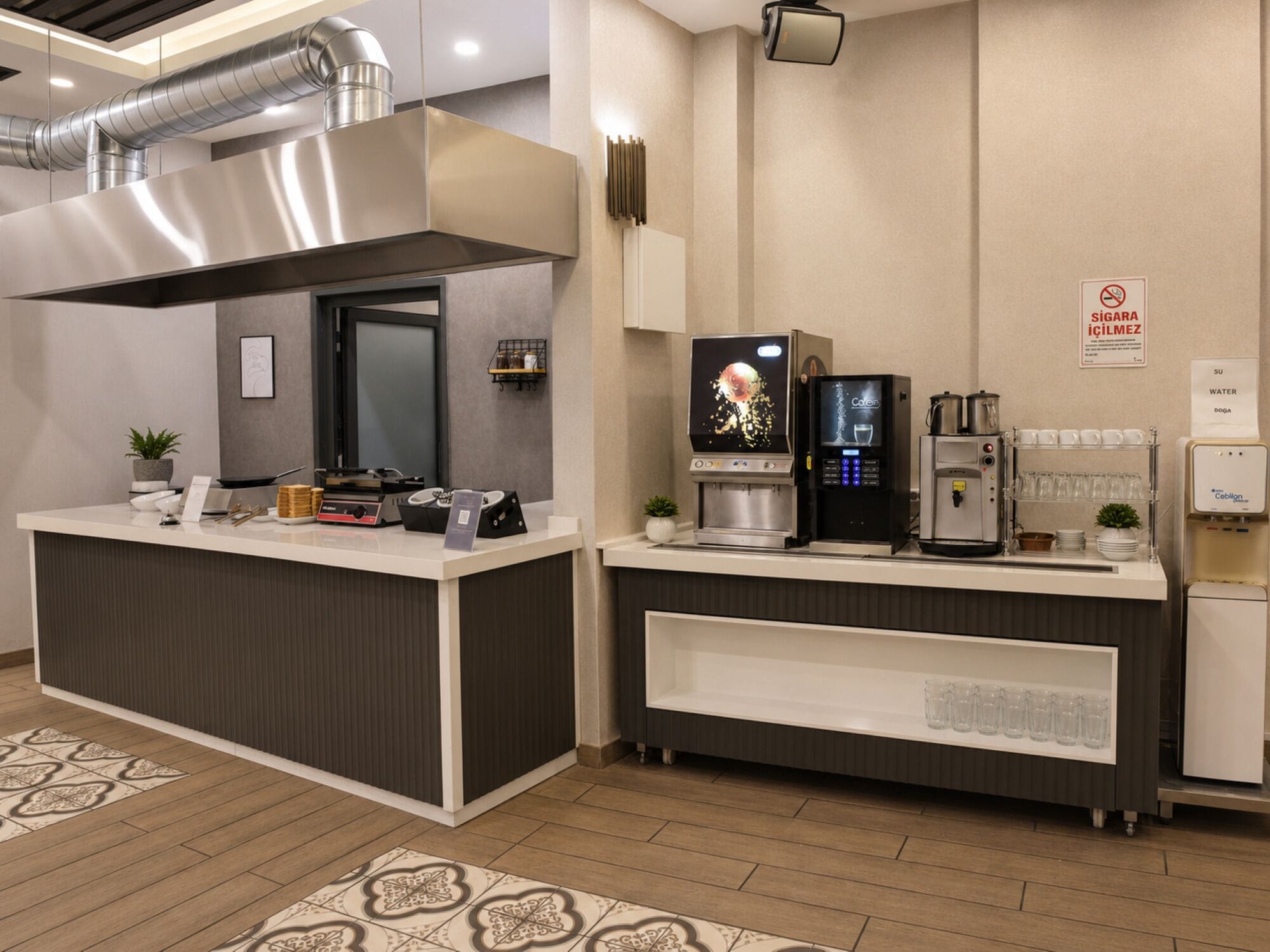 Una cocina moderna con una isla central, máquinas de café y dispensador de agua.