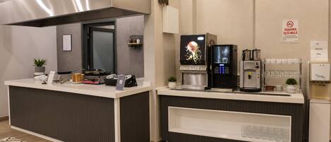 Una cocina moderna con una isla central, máquinas de café y dispensador de agua.