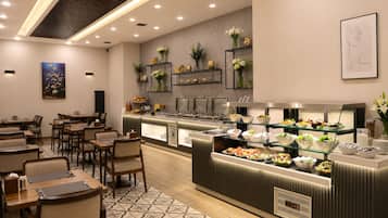 Un restaurante moderno con mesa de buffet, mesas y sillas.