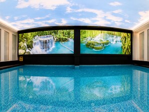 Una piscina con un murale a tema cascata sulle pareti.