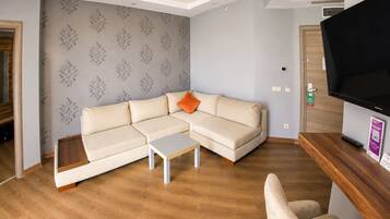 A modern living room with a sectional sofa, a coffee table, and a flat-screen TV.