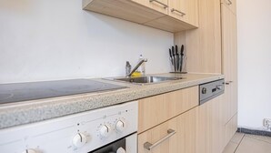 Une cuisine dotée d’un plan de travail en granit, d’un évier en acier inoxydable et d’un four encastré.