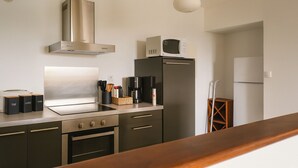 Moderni keittiö, jossa on ruostumattomasta teräksestä valmistetut kodinkoneet, sisäänrakennettu uuni ja mikroaaltouuni.