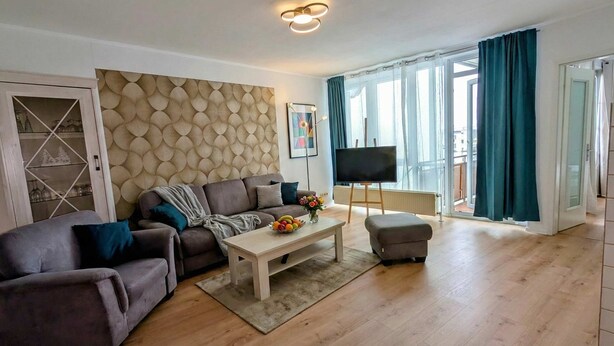 Ein modernes Wohnzimmer mit einer Couch, einem Couchtisch und einem Flachbildfernseher.