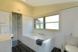 Ein modernes Badezimmer mit Badewanne, Toilette und Dusche.