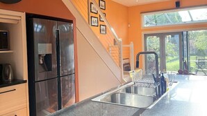 A modern kitchen with a stainless steel refrigerator, a built-in oven, and a granite countertop. - Brecon Cottage | Serene 3BR Blue Mountains Escape (Leura)