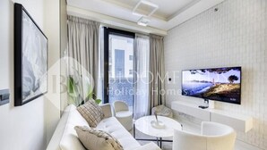 A modern living room with a sofa, chairs, a coffee table, and a TV. - Bloomfields Classic 2Br With Private (Dubai)