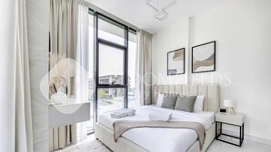 A modern hotel room with a large bed, a bedside table, and a view of the city through a large window. - Bloomfields Classic 2Br With Private (Dubai)
