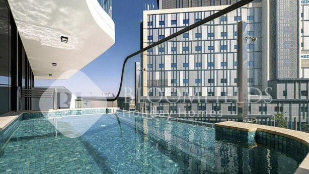 A modern hotel with a rooftop infinity pool, a glass facade, and a view of the city skyline. - Bloomfields Classic 2Br With Private (Dubai)