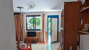 A spacious room with a large window, a wooden cabinet with hats, and a television. - Apartment Oasis Costa Calma (Costa Calma)