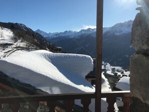 A snow-covered mountain landscape with a stone building and a wooden fence. - Brenlo (La Salle)