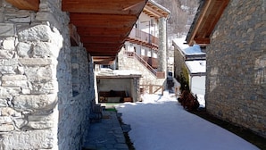 A narrow snow-covered alleyway flanked by stone buildings with wooden balconies. - Brenlo (La Salle)