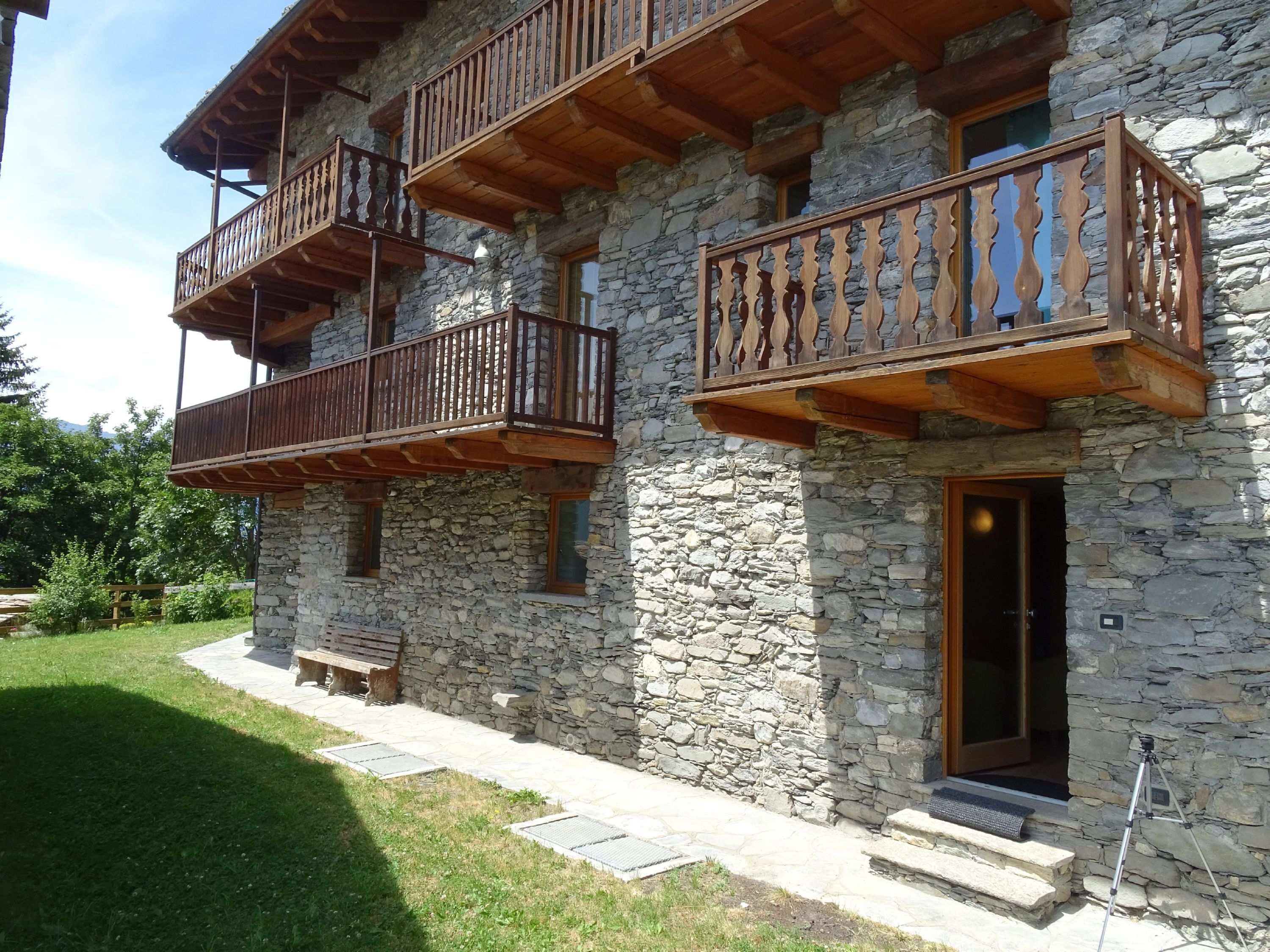 A stone building with wooden balconies and a stone entrance.