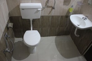Un baño pequeño con inodoro, lavamanos y ducha.
