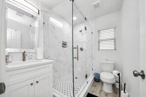 Een douche, handdoeken, zeep, toiletpapier