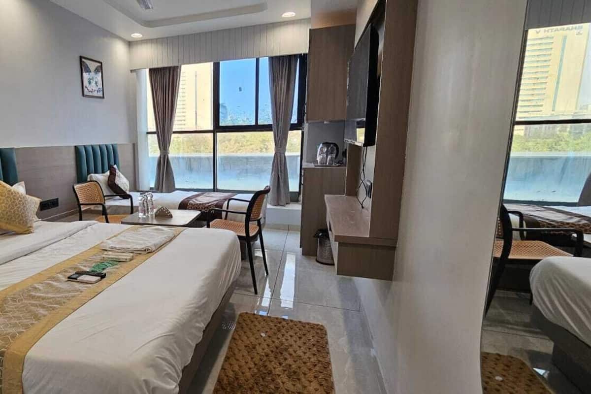 Une chambre d’hôtel avec un grand lit, une table à manger et une vue sur la ville.
