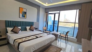 Ein modernes Hotelzimmer mit einem großen Bett, einem kleinen Tisch, einem Stuhl und einem Fernseher.