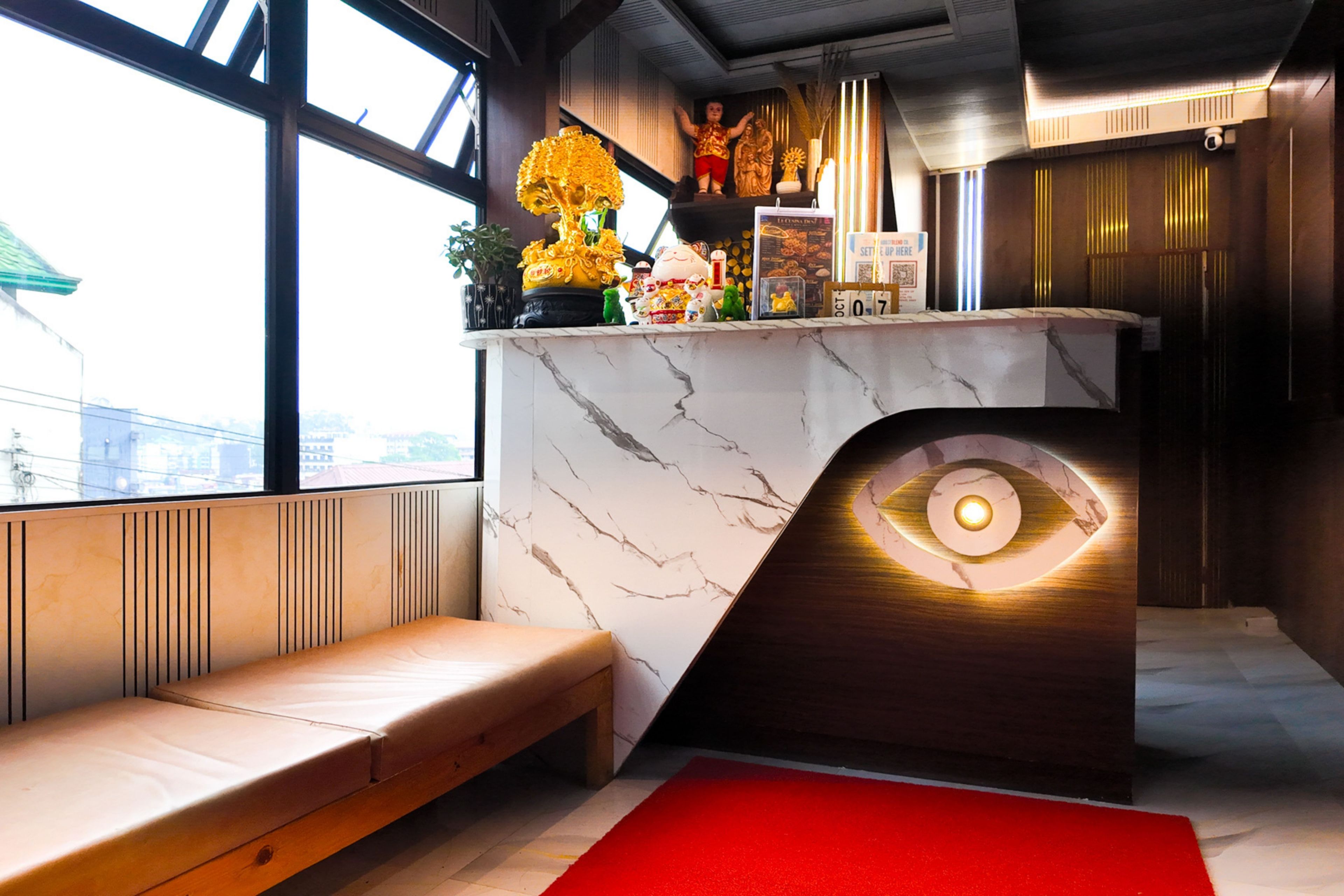 Un intérieur moderne avec un comptoir en marbre, un banc et un élément de design original en forme d’œil.