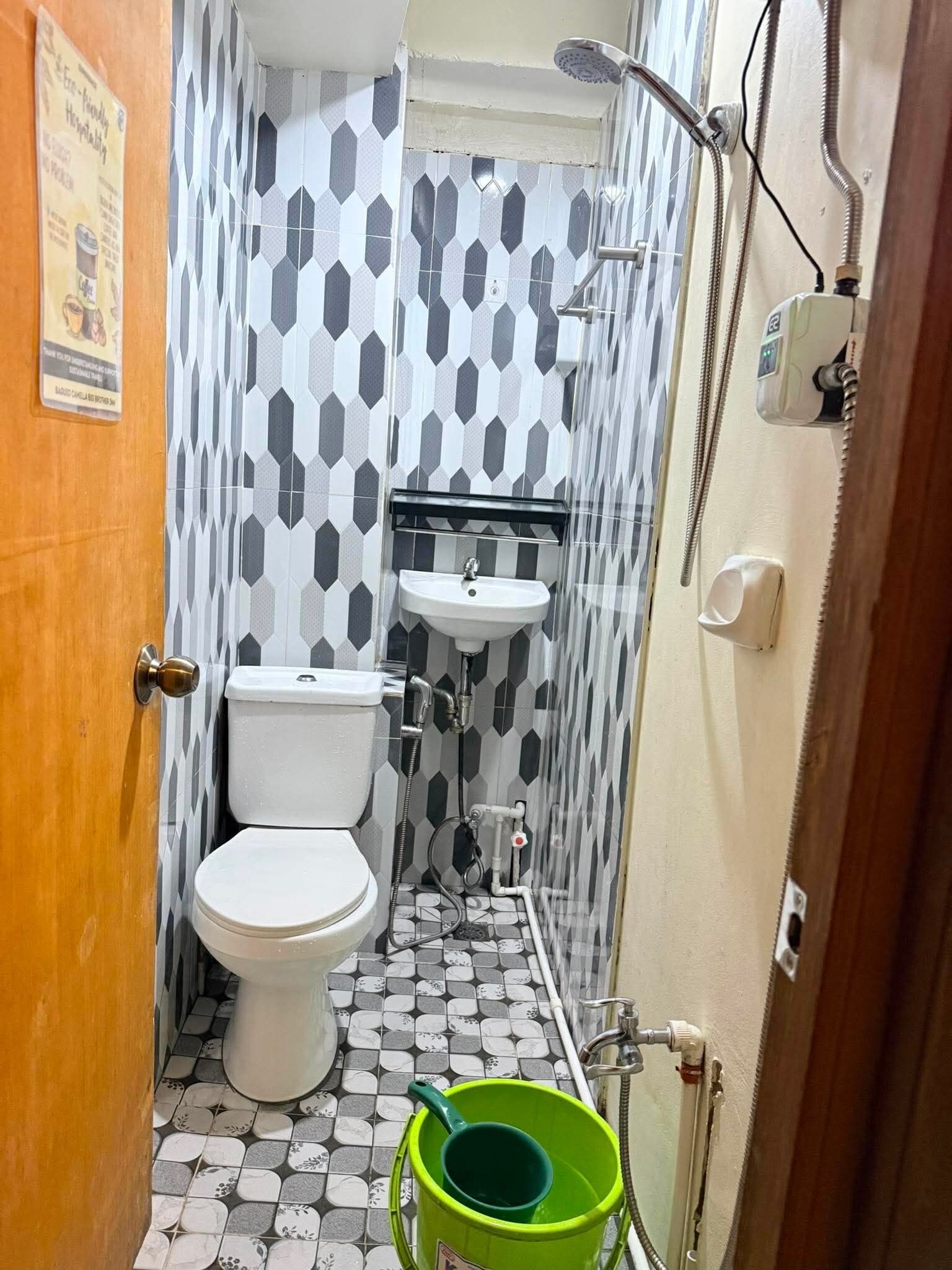 A small bathroom with a toilet, sink, and shower.
