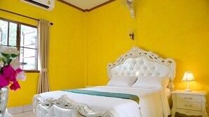 Une chambre avec un grand lit, une table de chevet et une fenêtre avec des rideaux.