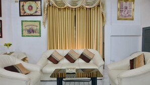 Un salon comprenant un canapé, une table basse et des rideaux.