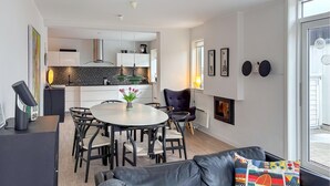 Un salon moderne comprenant un coin repas, une cheminée et une vue sur l’extérieur.