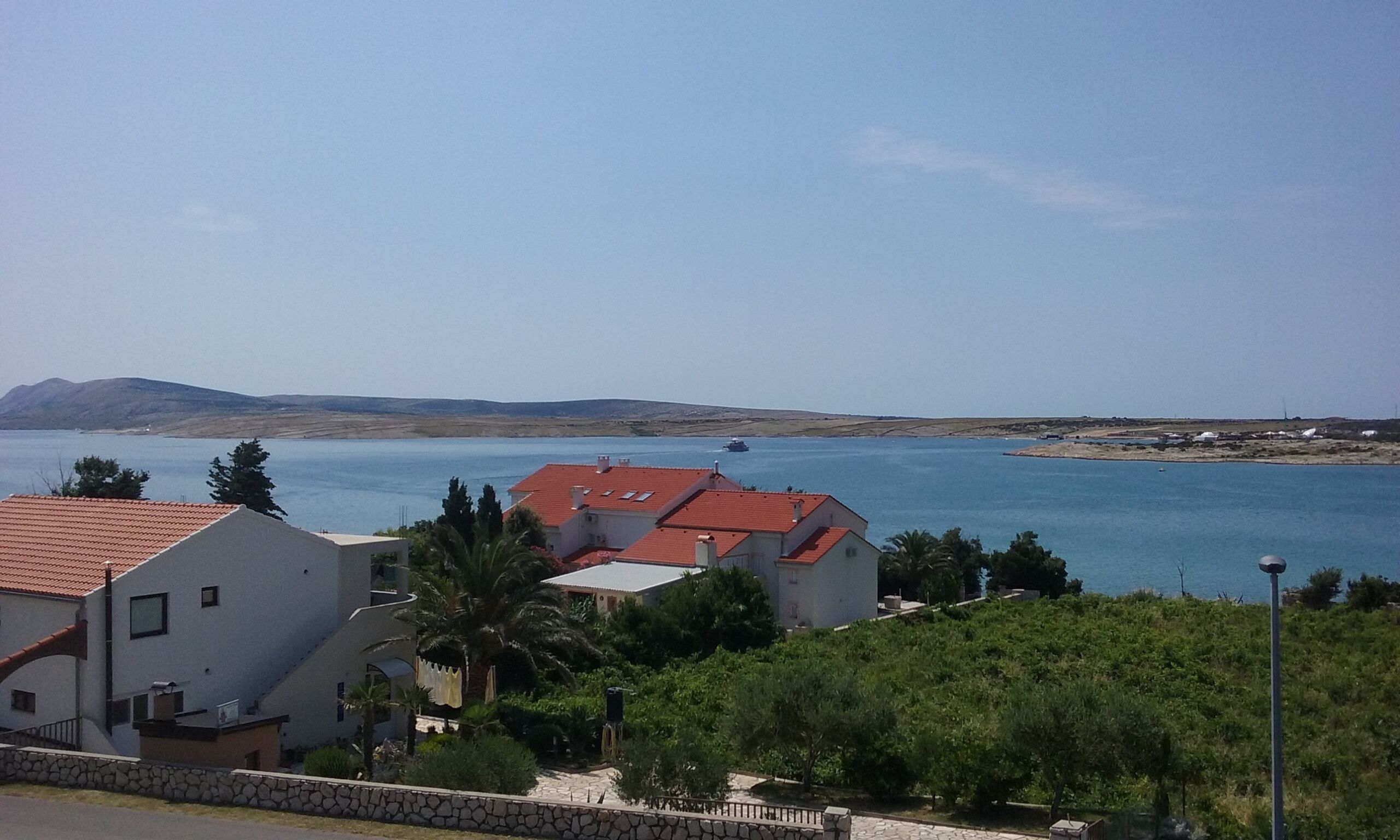 A coastal view with buildings and a clear blue sea.
