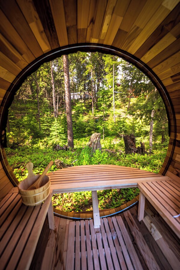 A circular wooden structure with benches and a view of a forest.