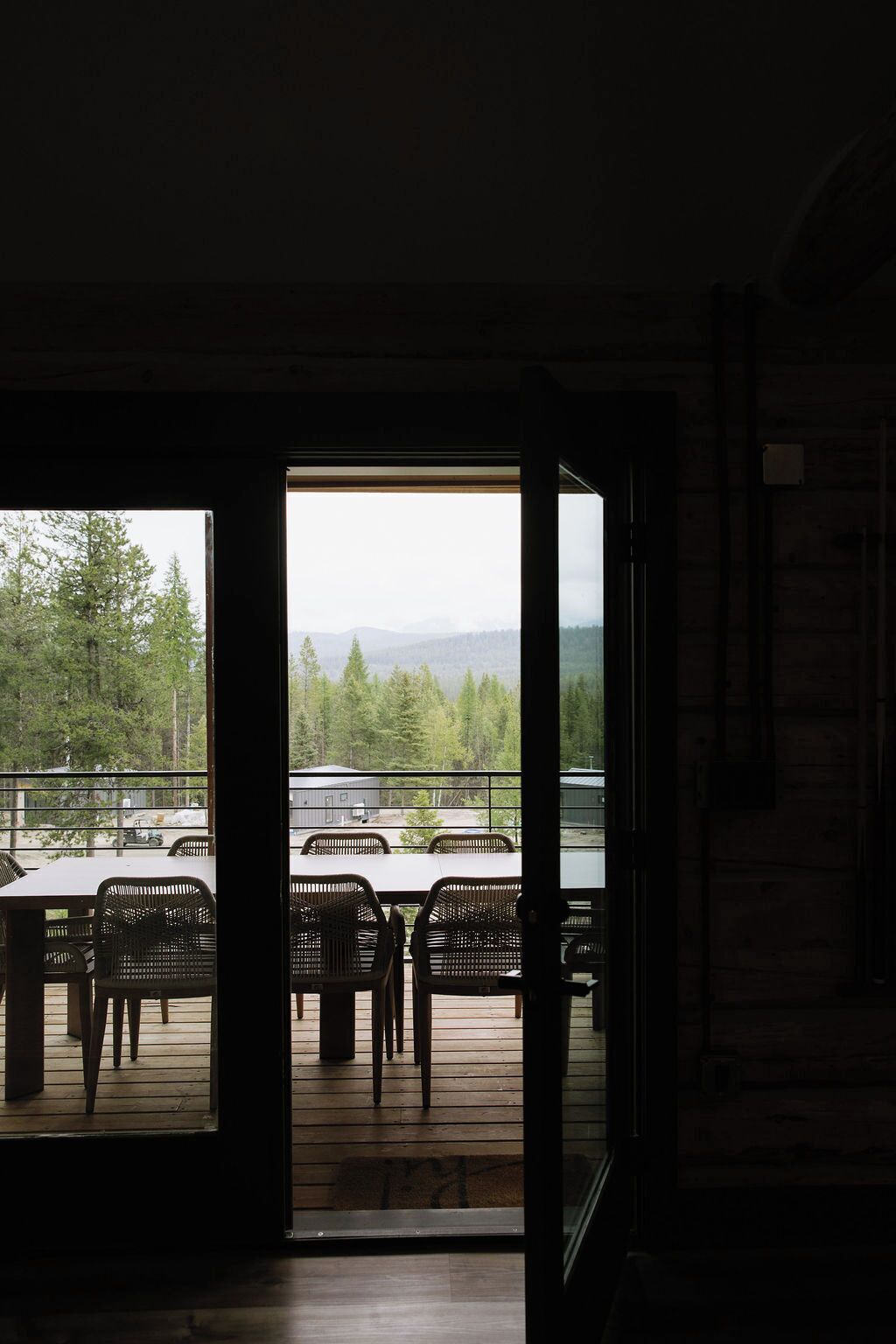 An interior space with a view of a deck area outside.