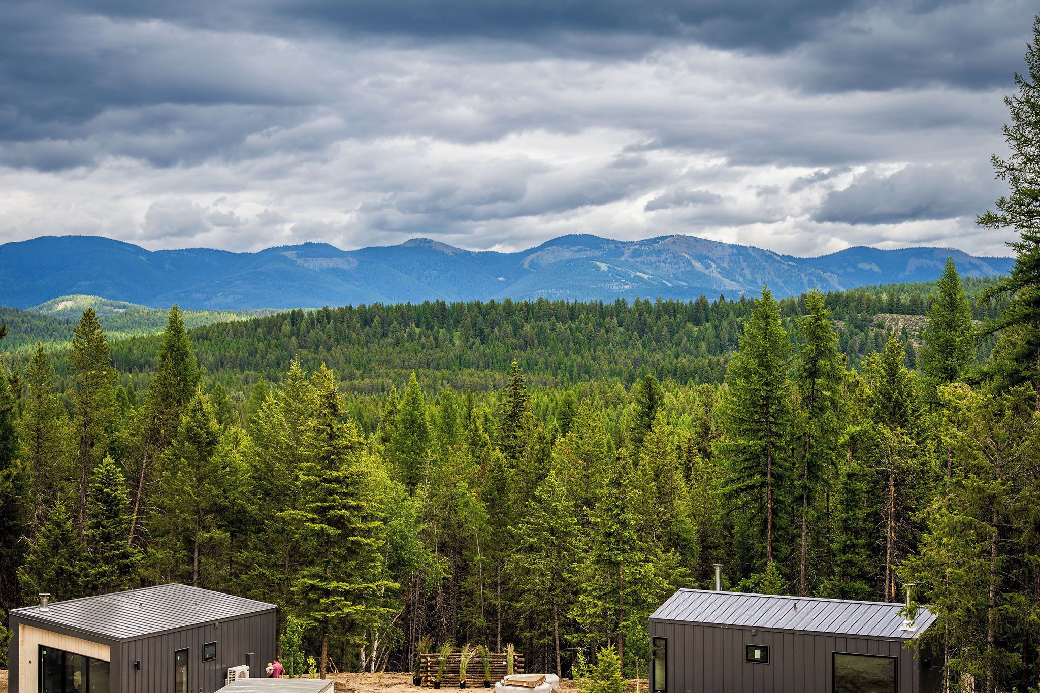 A cabin with a view of a forest and mountains.
