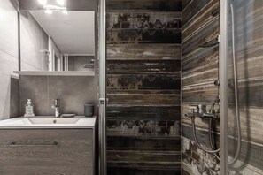A modern bathroom with a large mirror, a sink, and a shower area. - Athenian Central Escape (Athens)