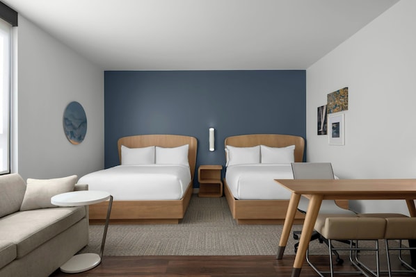 A modern hotel room with two beds, a sofa, a small table, and a desk. - Element by Marriott Boise Downtown (Boise)